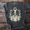 Dark gray t-shirt with a cream graphic of a ritualistic scene with people and a figure on a pyre.