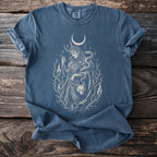 Blue t-shirt with white graphic of Loki holding a fox mask and snake under moon.