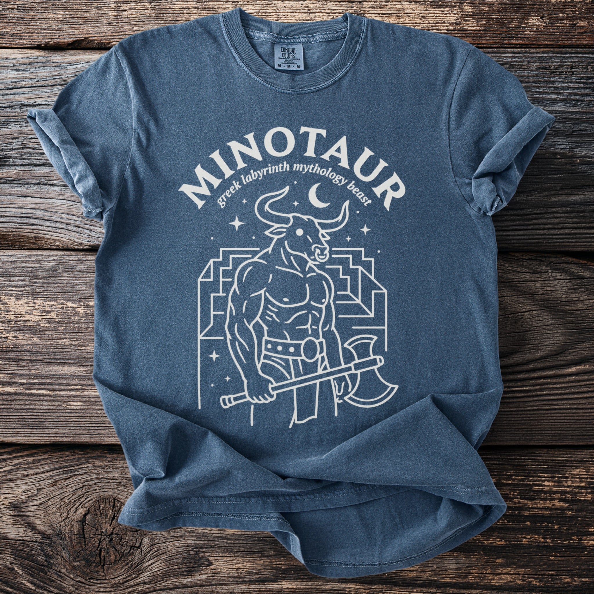 Blue t-shirt with white line art of a Minotaur holding an axe in a labyrinth.