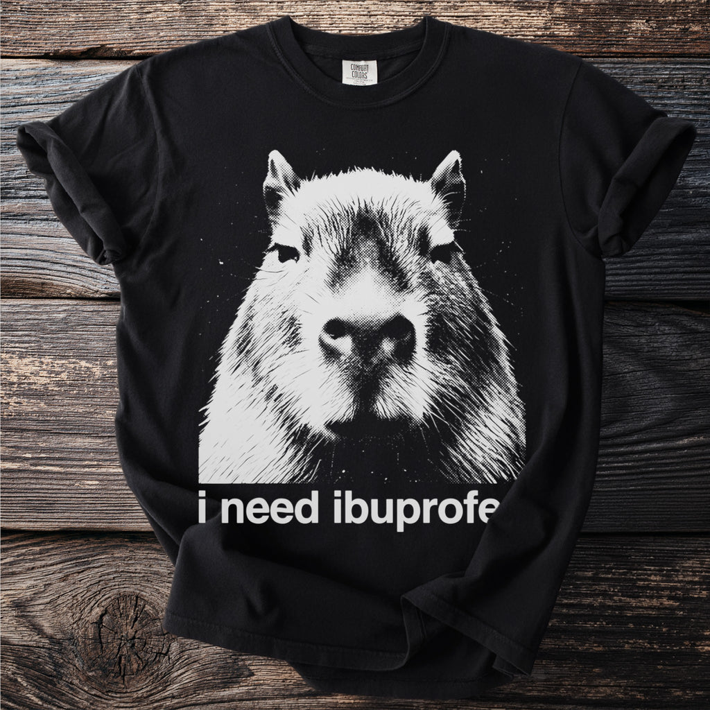 Black t-shirt with a close-up black and white graphic of a capybara face and text that reads "i need ibuprofe".