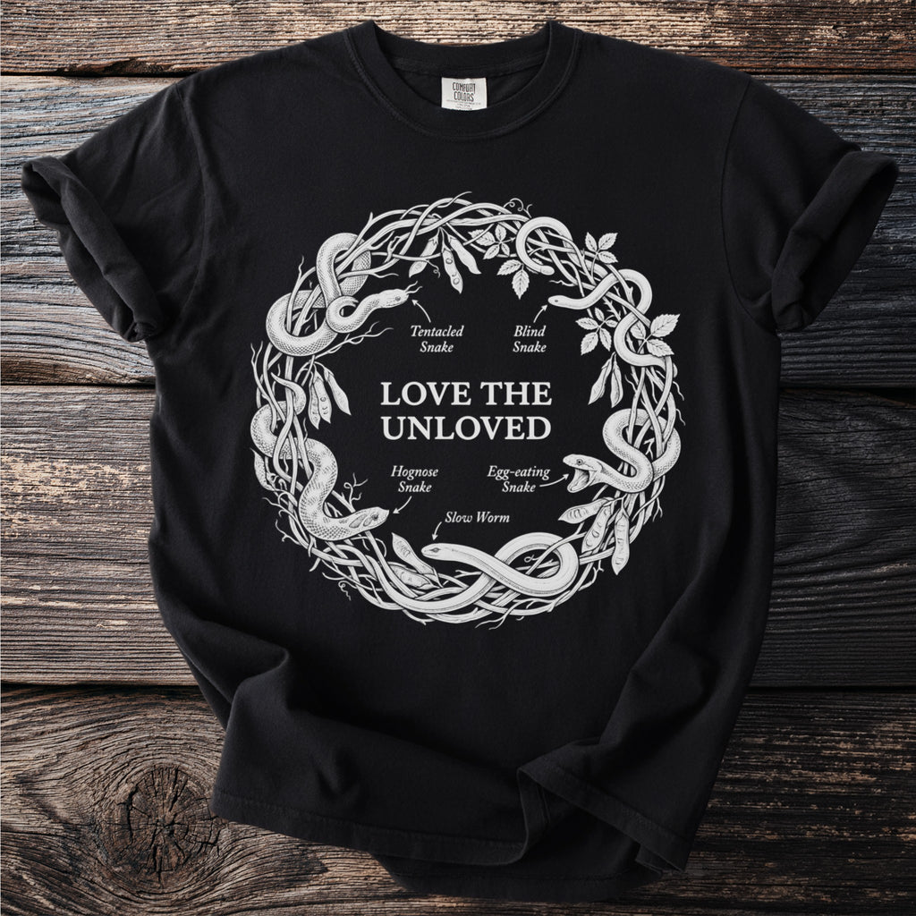 Black shirt with white circular illustration of snakes and legumes, text "Love The Unloved."