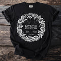 Black shirt with white circular illustration of snakes and legumes, text "Love The Unloved."