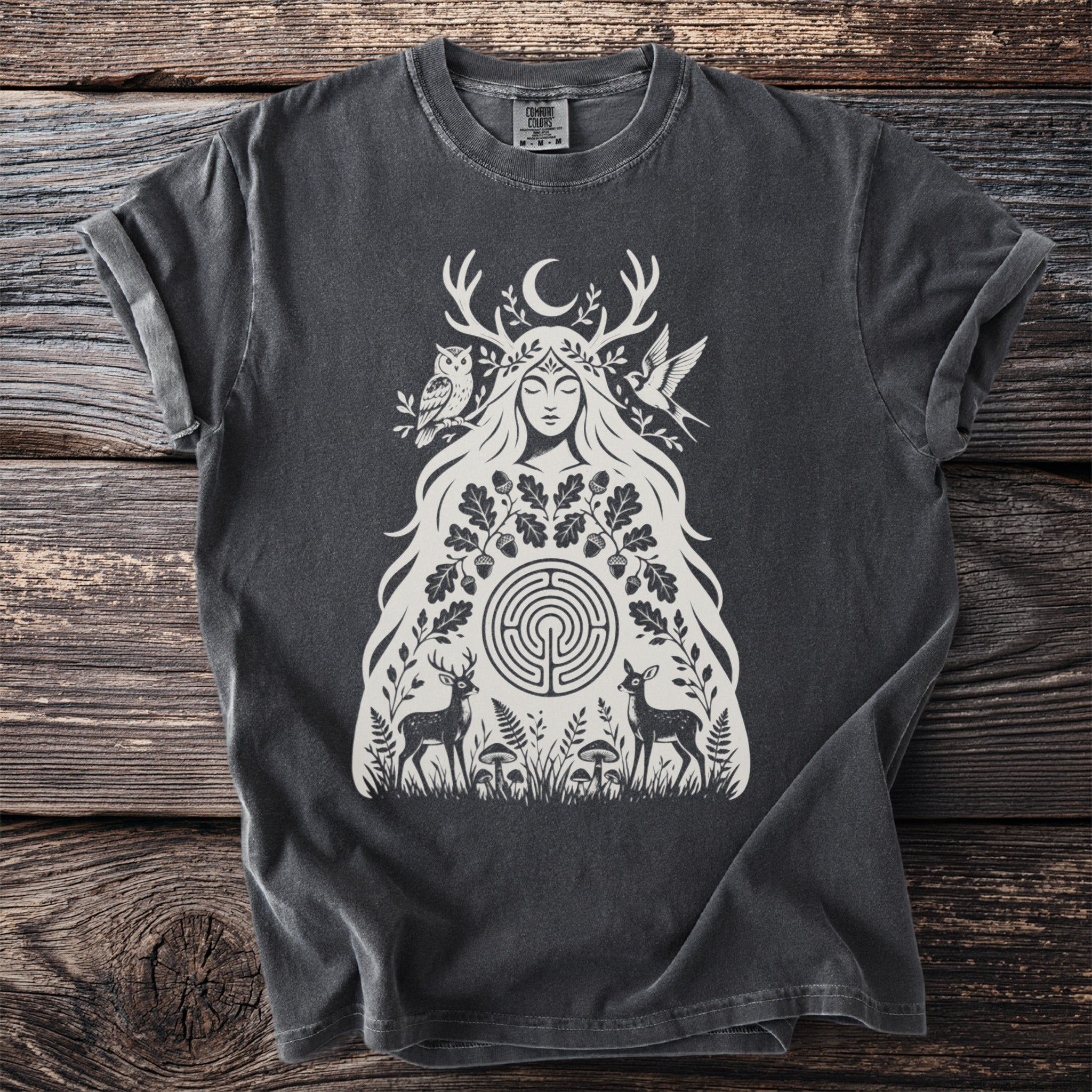 Dark gray t-shirt with a cream illustration of a goddess surrounded by nature elements.