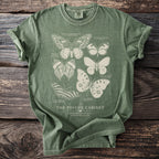 Green t-shirt featuring illustrated butterflies and the text "The Psyche Cabinet".