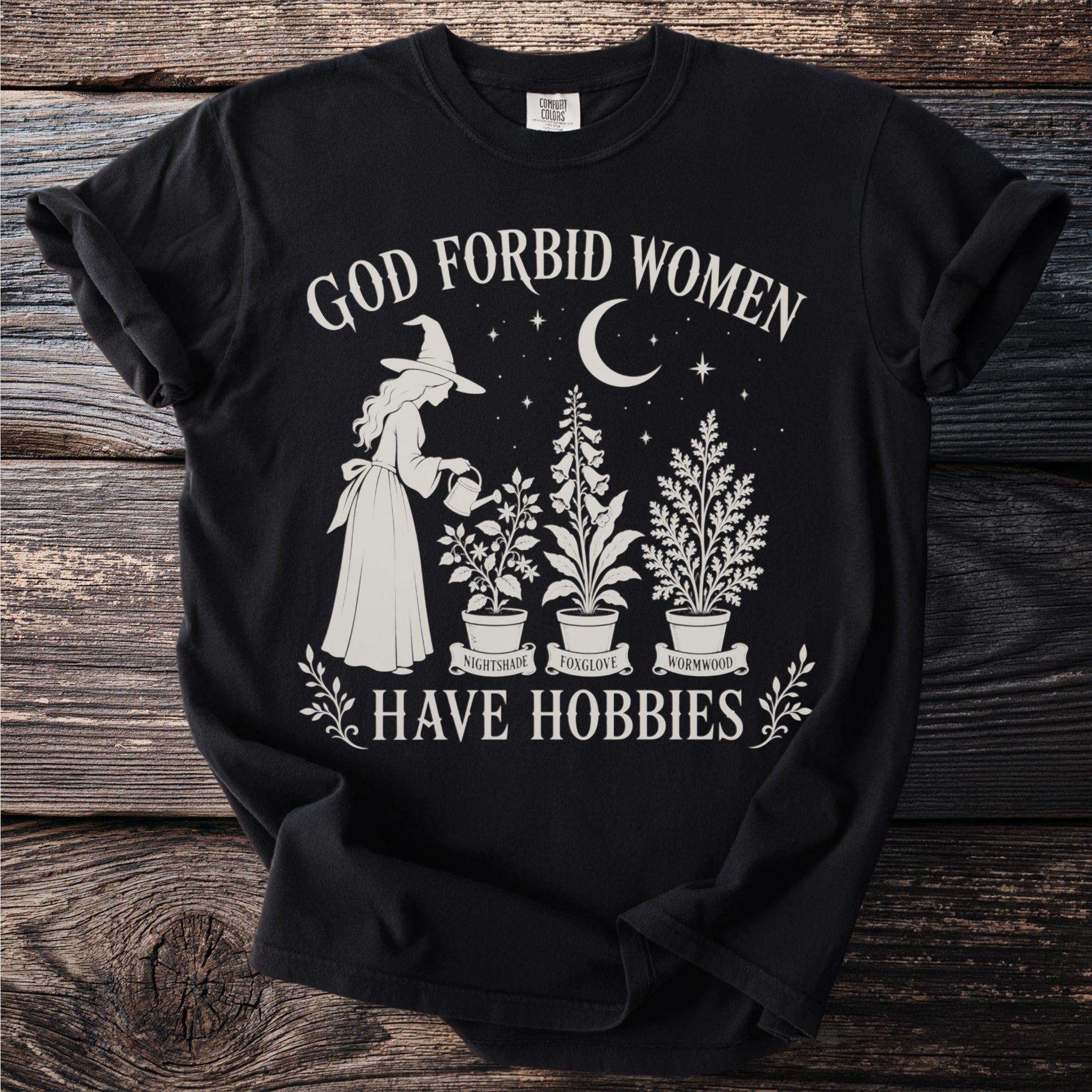 Black t-shirt with witch gardening plants and text "God Forbid Women Have Hobbies".