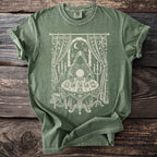 Green t-shirt with a cream screen-print of a fortune teller with a crystal ball, tarot cards, and a cat.