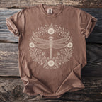 Brown t-shirt with a cream-colored dragonfly and floral design in a circular frame.