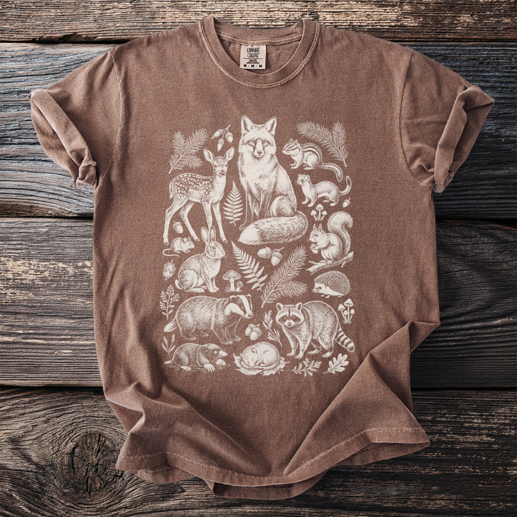Brown t-shirt with a white line drawing of woodland animals and foliage.