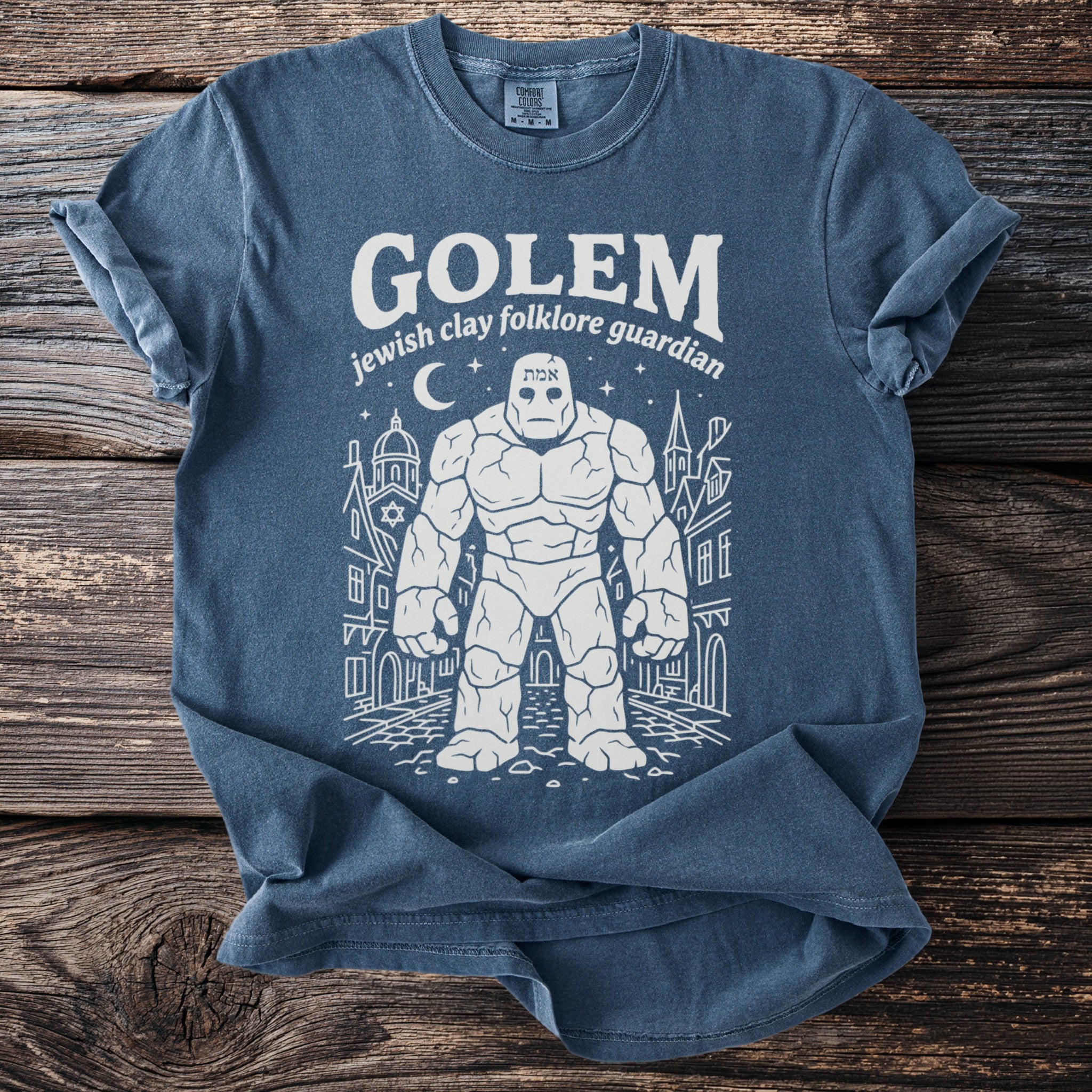 Blue t-shirt with a white line drawing of a golem and city buildings.