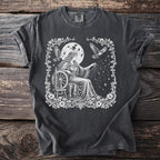 T-shirt with white graphic of woman spinning stars under moon with birds.