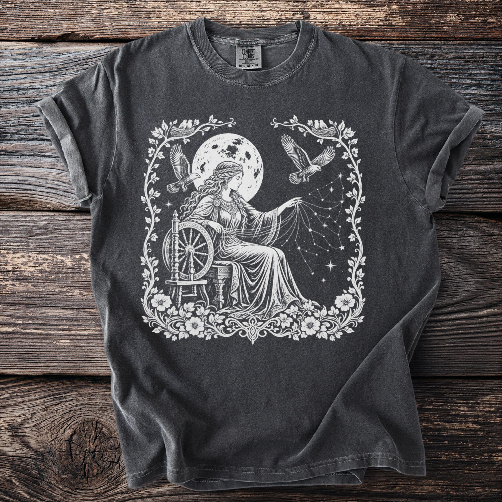 T-shirt with white graphic of woman spinning stars under moon with birds.