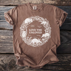 Brown t-shirt with white line art of animals and "Love the Unloved" text.
