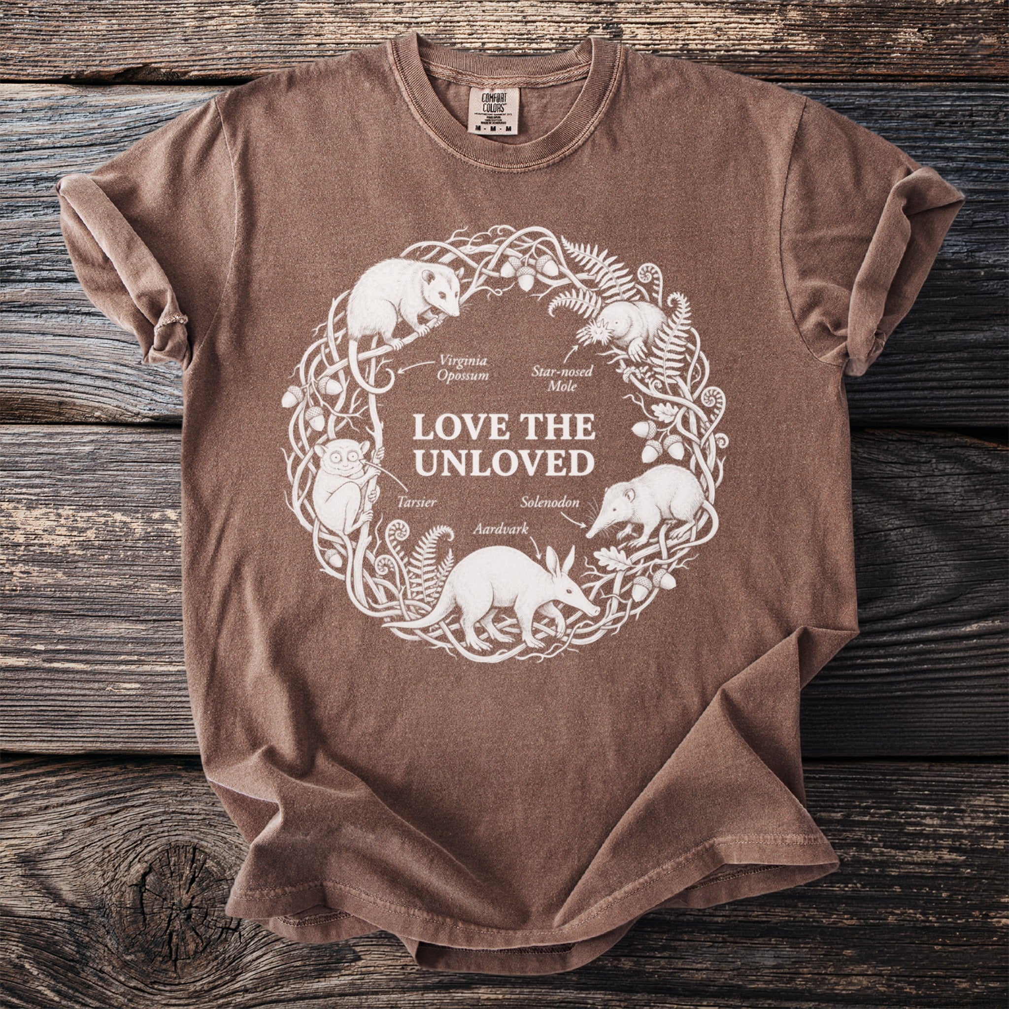 Brown t-shirt with white line art of animals and "Love the Unloved" text.