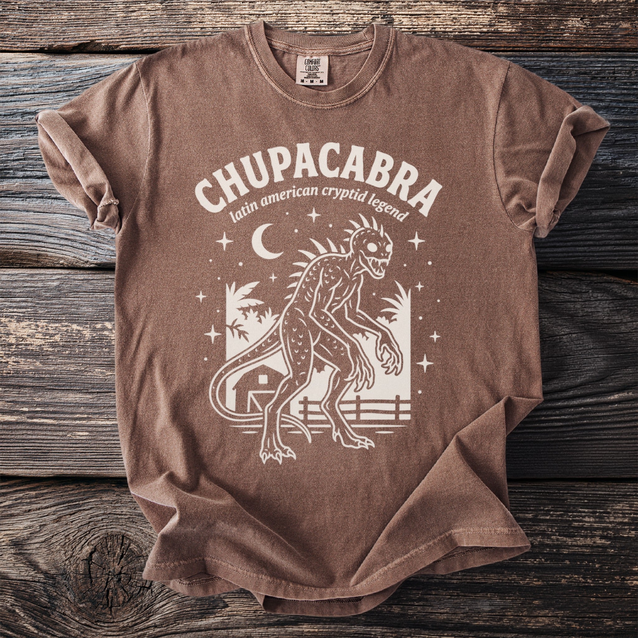 Brown t-shirt with white Chupacabra graphic and text "latin american cryptid legend".