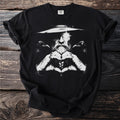 Black t-shirt with a greyscale graphic of a man with a beard and hat between two ravens.