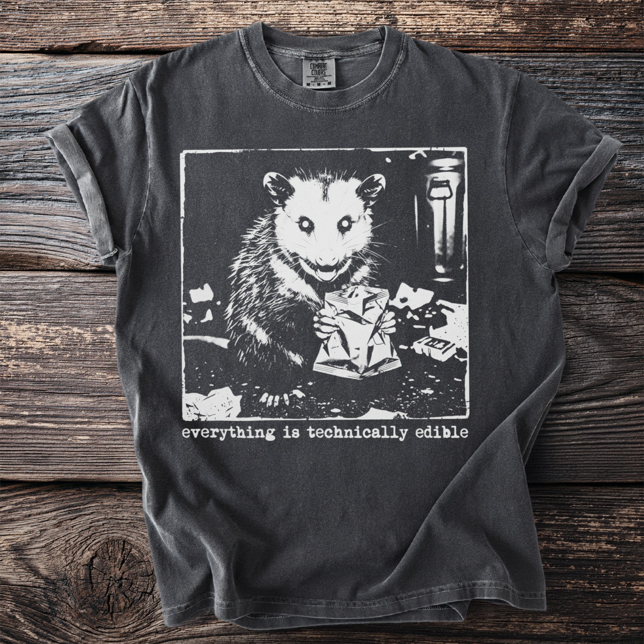 Opossum holding a bag of chips on a dark gray t-shirt with text.