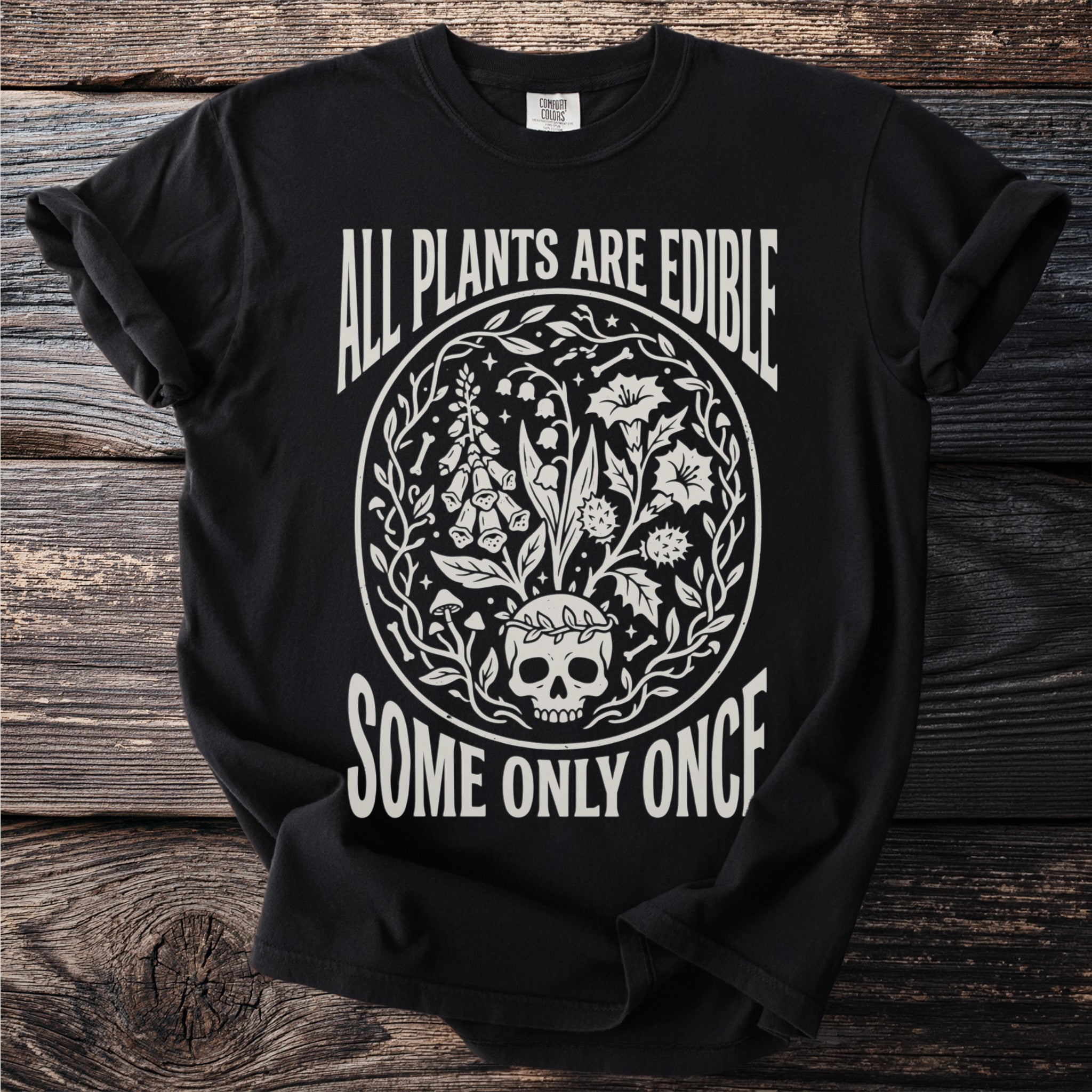 Black t-shirt with "All Plants Are Edible Some Only Once" text and floral skull graphic.