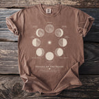 Brown t-shirt with "Phases of the Moon" graphic showing lunar cycle stages.
