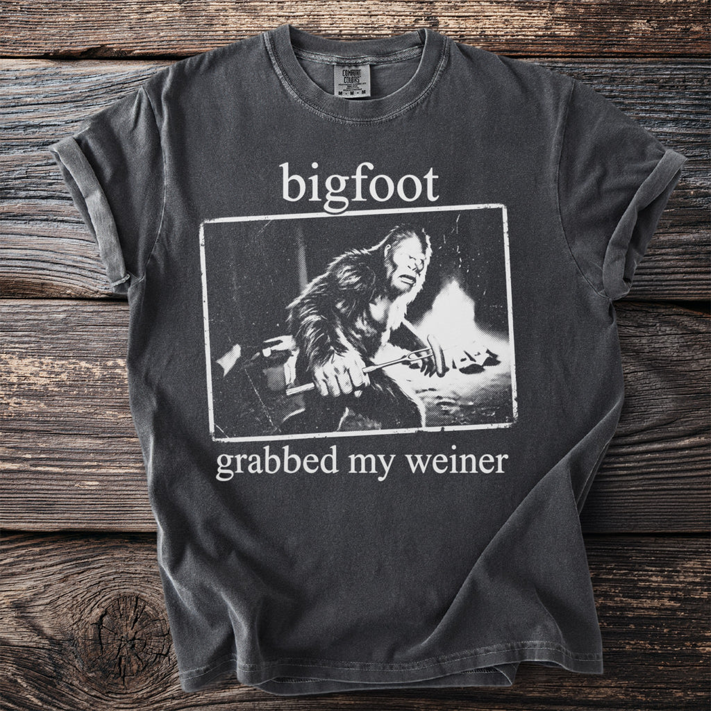 Dark grey t-shirt with white text "bigfoot grabbed my weiner" and a Bigfoot illustration.