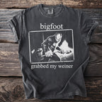 Dark grey t-shirt with white text "bigfoot grabbed my weiner" and a Bigfoot illustration.