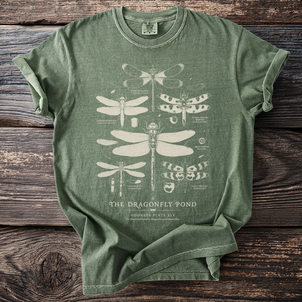 Green t-shirt with white illustration of dragonflies and text "The Dragonfly Pond".
