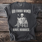 Skeleton sitting in a chair reading with text: God forbid women have hobbies.