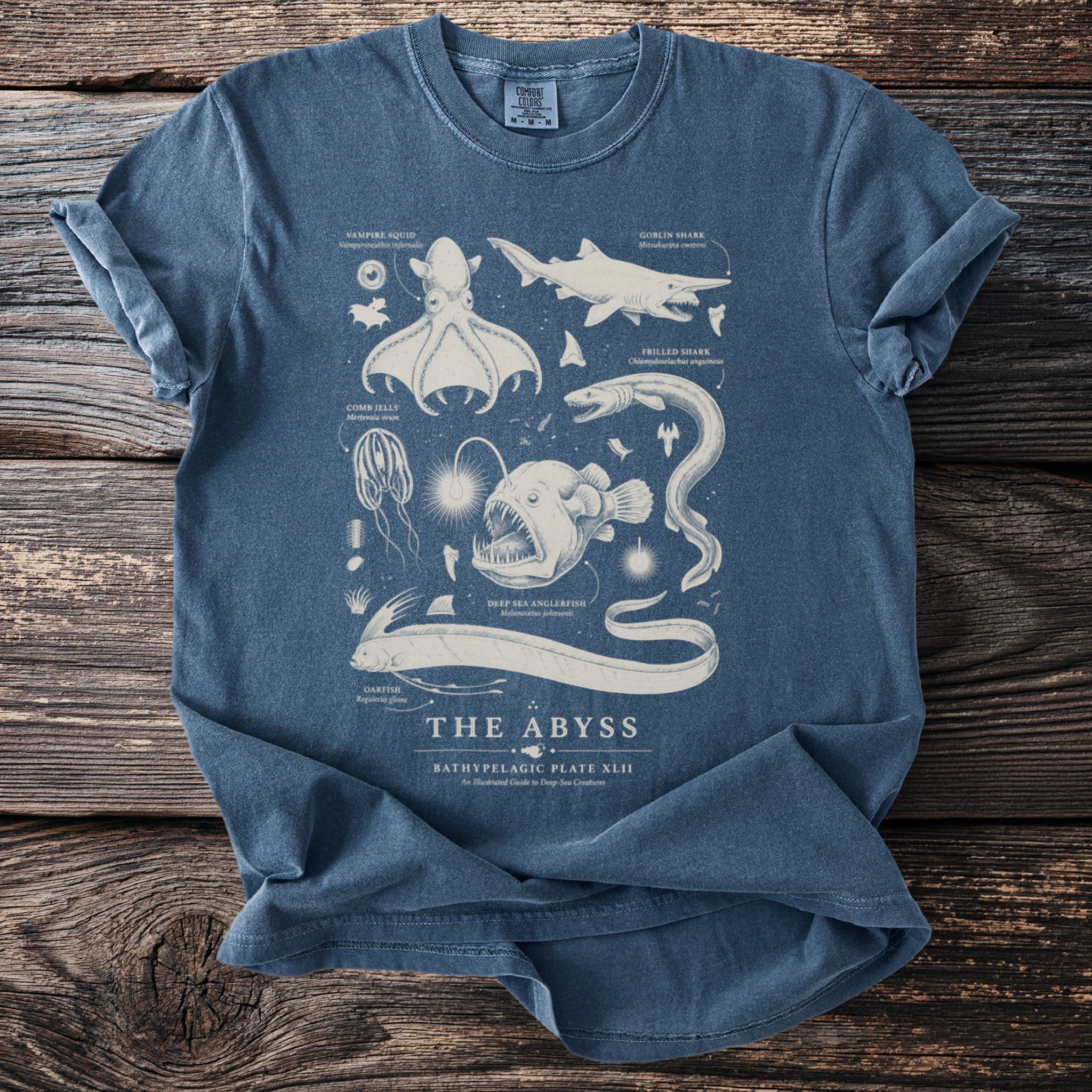 Blue t-shirt with vintage-style illustrations of deep-sea creatures and text "The Abyss."