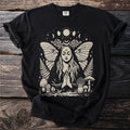 Black t-shirt with witchy moth woman, moon phases, mushrooms, ferns and roses graphic.