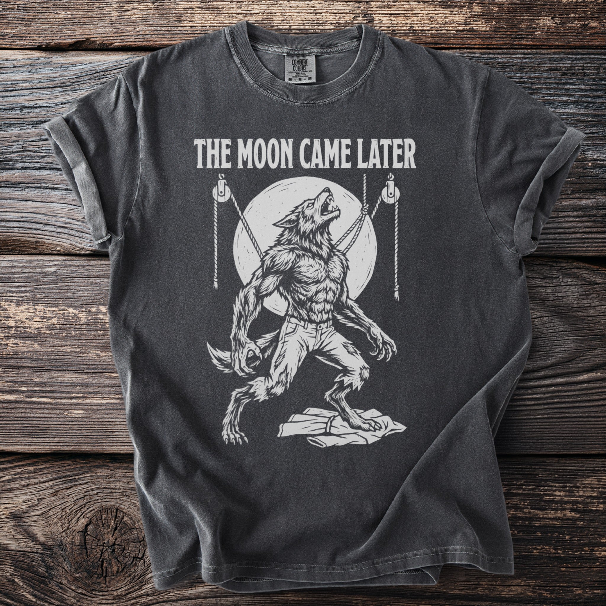 Dark t-shirt with graphic of howling werewolf and text "THE MOON CAME LATER".
