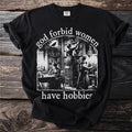 Black t-shirt with "god forbid women have hobbies" text and library illustration.