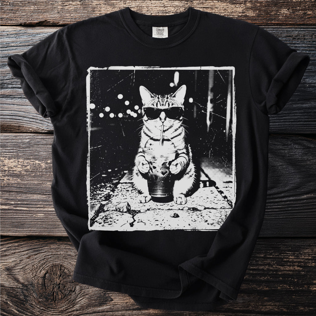 T-shirt with a black and white graphic of a cat wearing sunglasses and drinking a beverage.