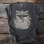 T-shirt with a cream-colored print of a dragonfly, mushrooms, ferns, and clover.