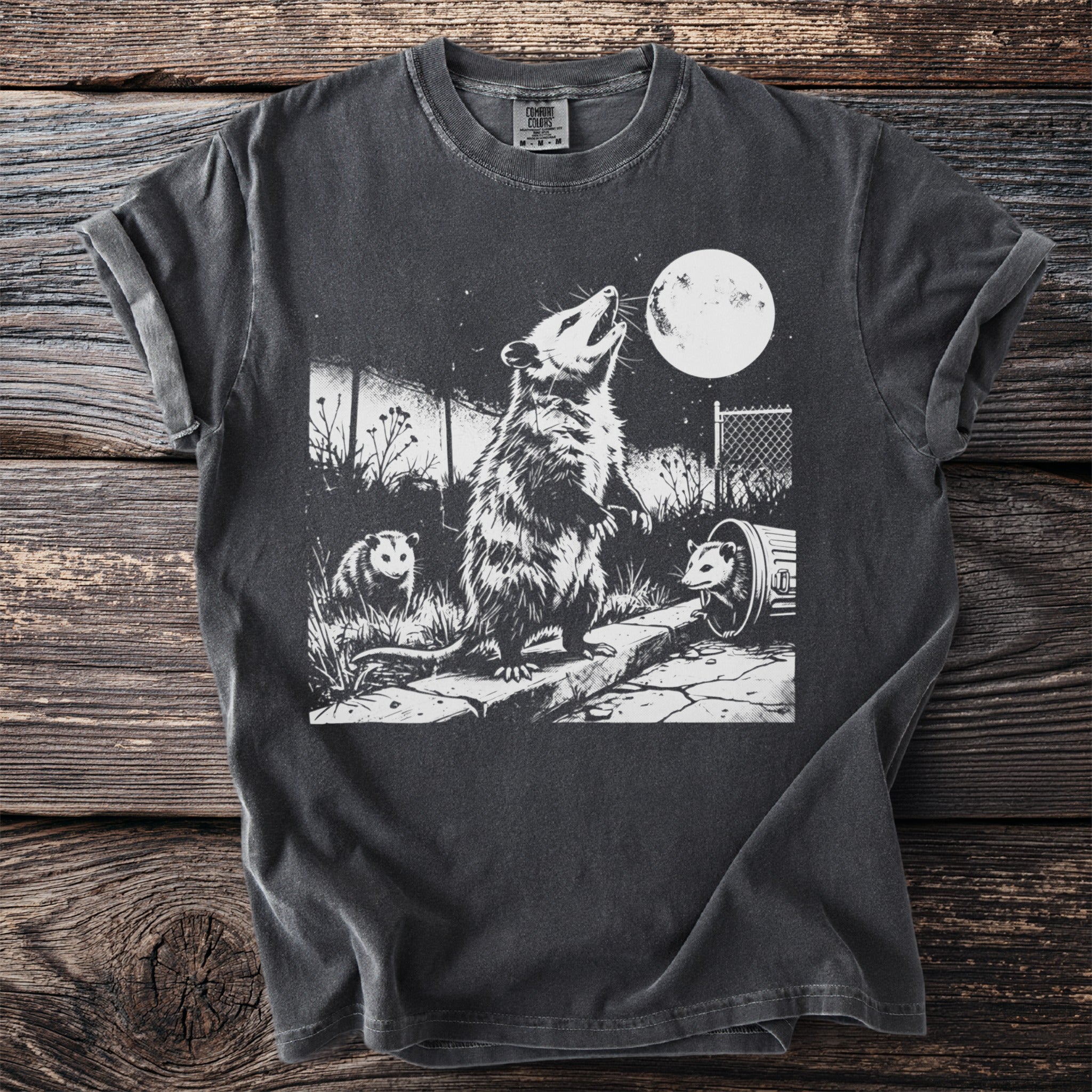 Opossums howl at the moon on a dark t-shirt with a graphic print.