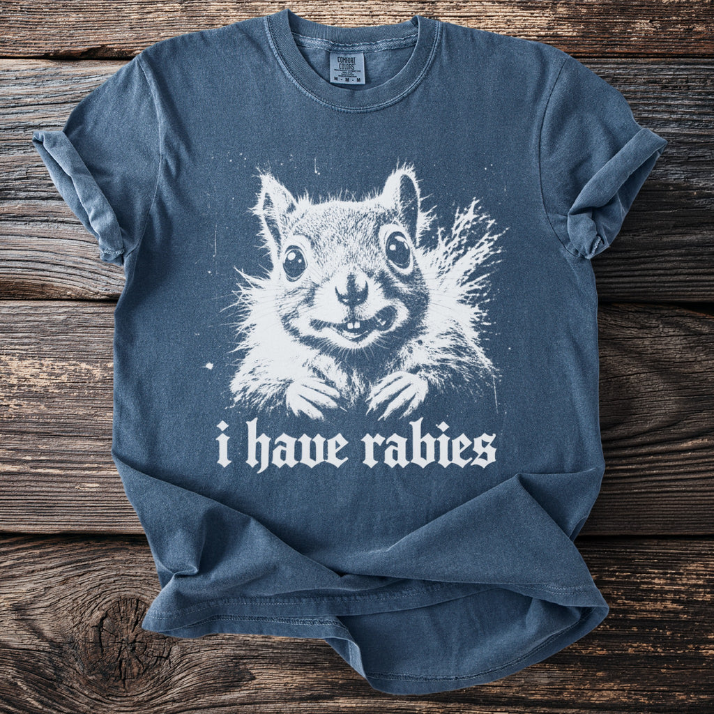Blue t-shirt with white graphic of a squirrel and text "i have rabies".