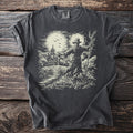 Dark gray t-shirt with a scarecrow with arms outstretched in a cornfield, a small church at the left and the moon rising behind.