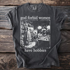 Dark grey t-shirt with "god forbid women have hobbies" and vintage library illustration.
