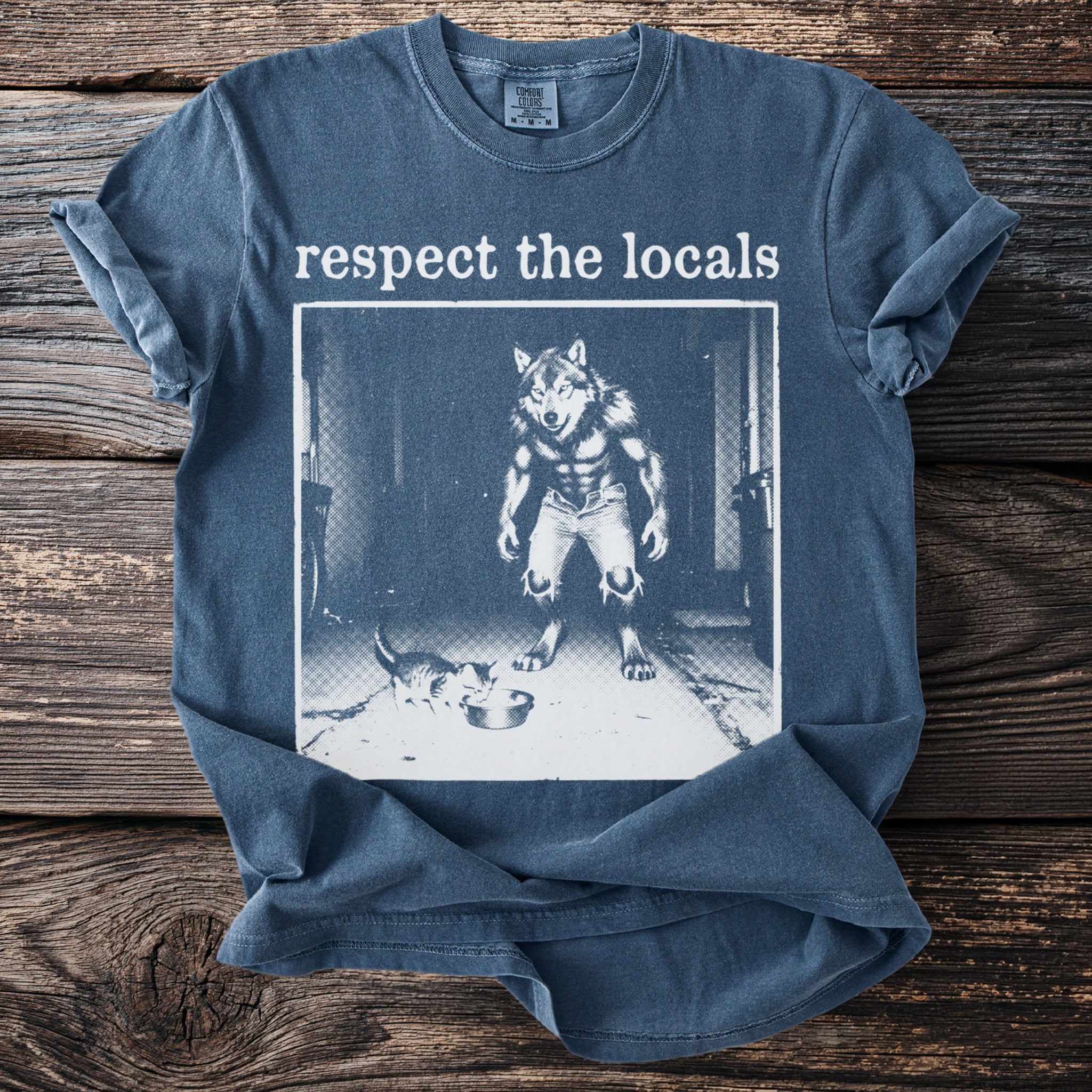 Blue t-shirt with "respect the locals" text and werewolf and cat graphic.