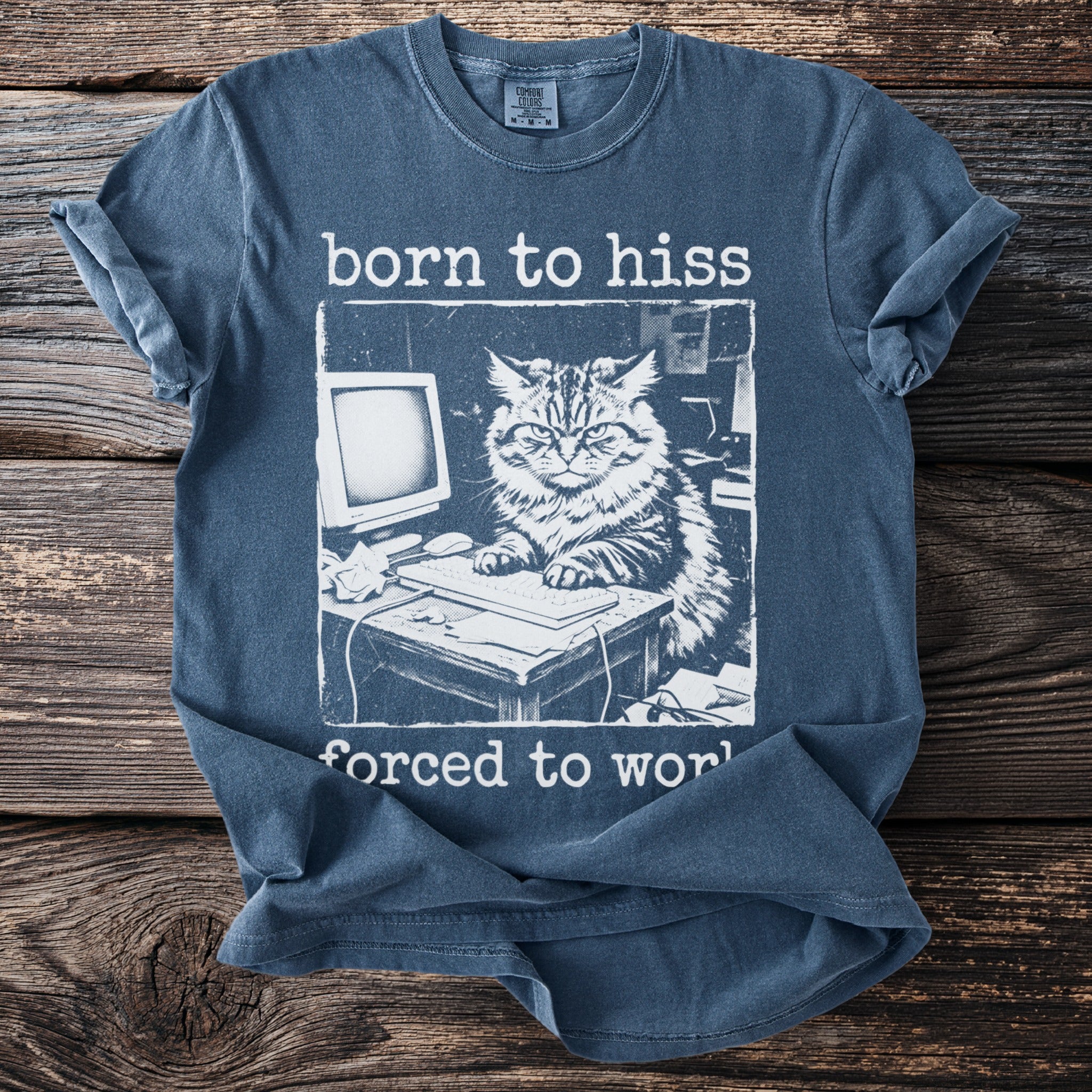 Blue t-shirt with distressed graphic of a cat at a computer, text "born to hiss forced to work."