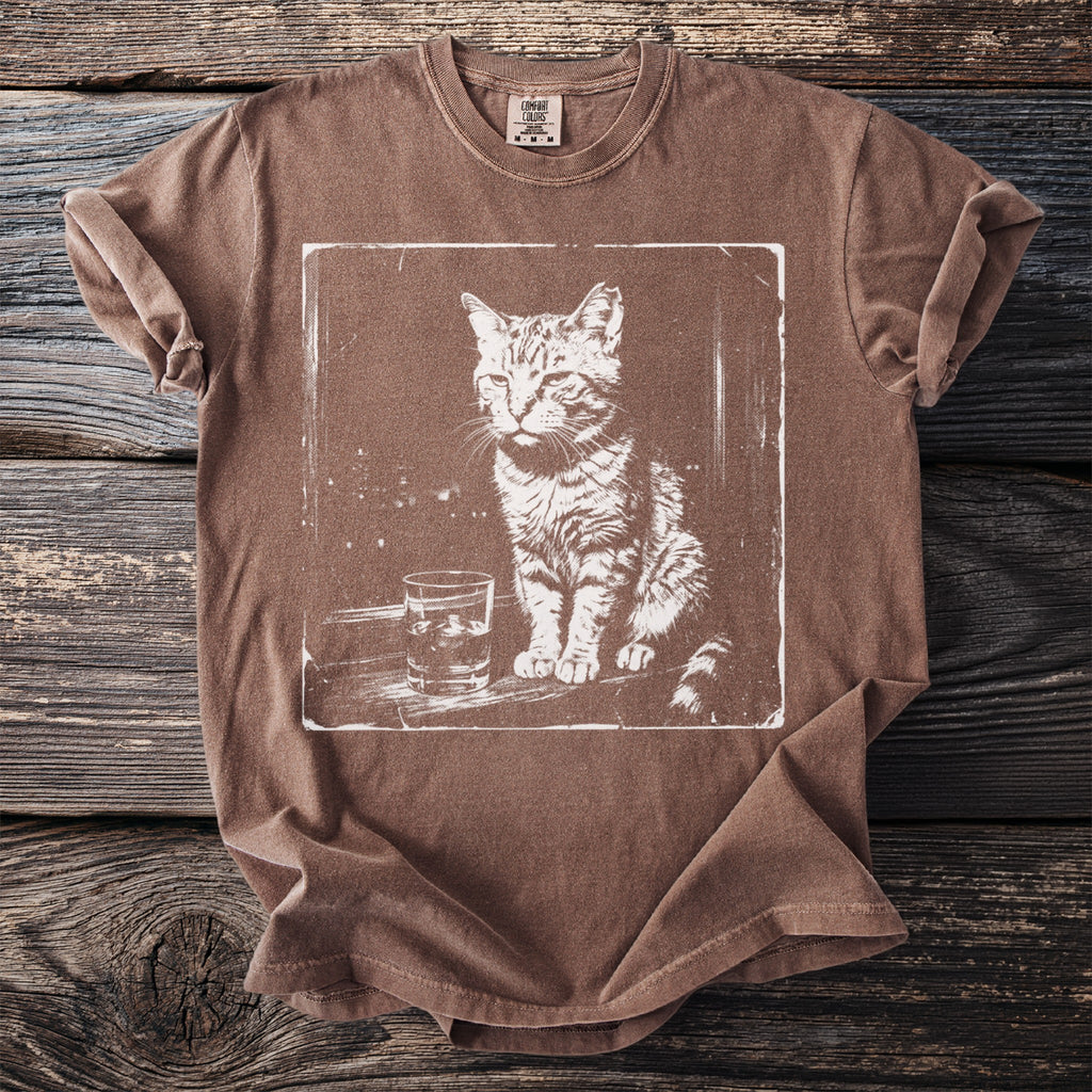 Brown Comfort Colors t-shirt with a distressed print of a cat sitting by a glass of water.