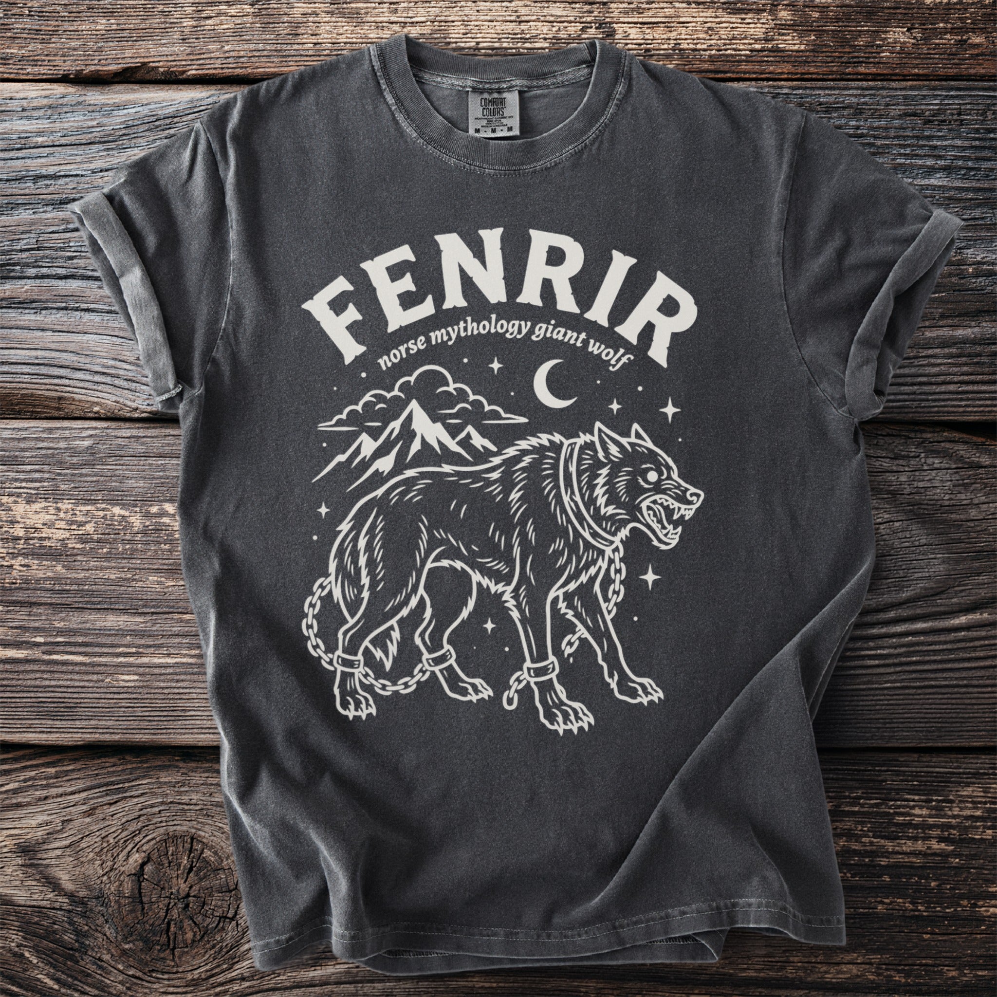 Dark grey t-shirt with white graphic of Fenrir, Norse mythology giant wolf, chained with mountains and moon.
