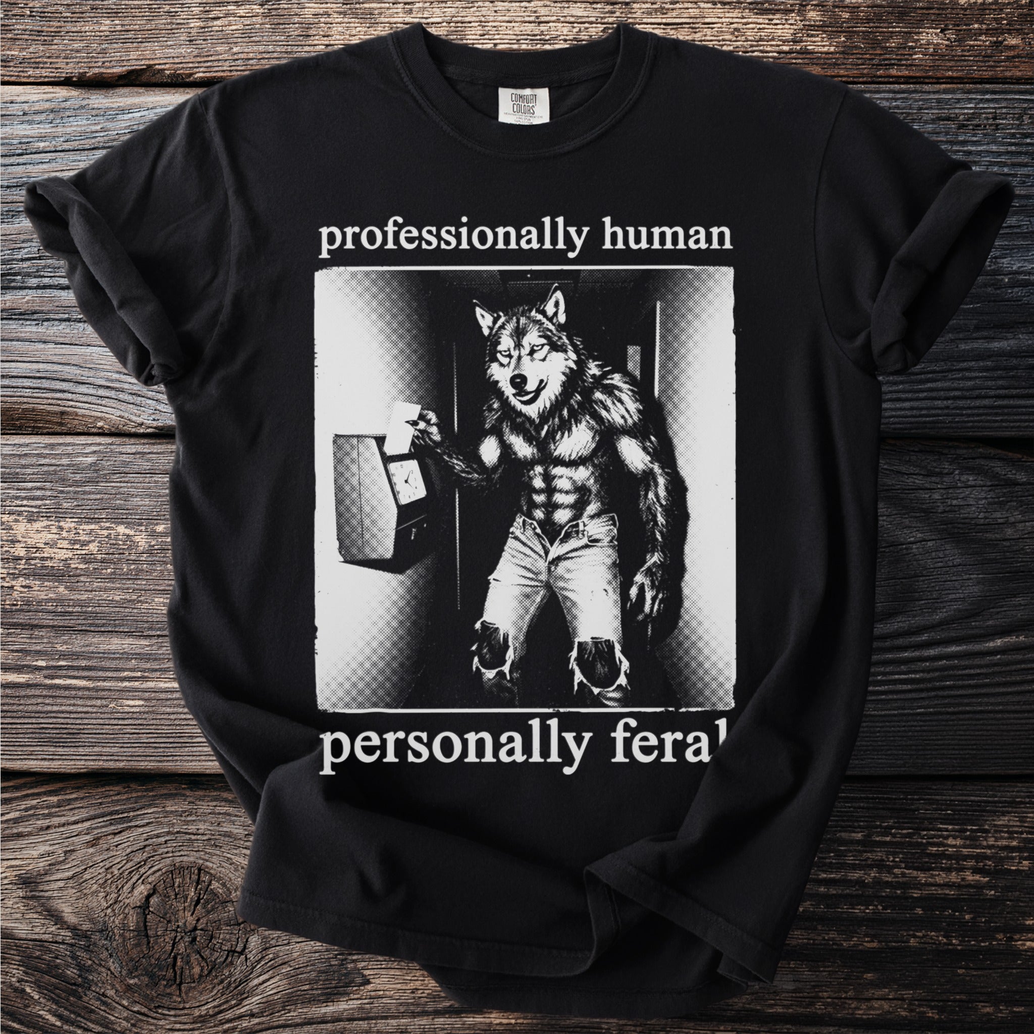 Black t-shirt with a werewolf clocking in, text reads "professionally human, personally feral".