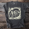 Dark gray t-shirt with cream-colored graphic of four skeletons running through a forest scene.