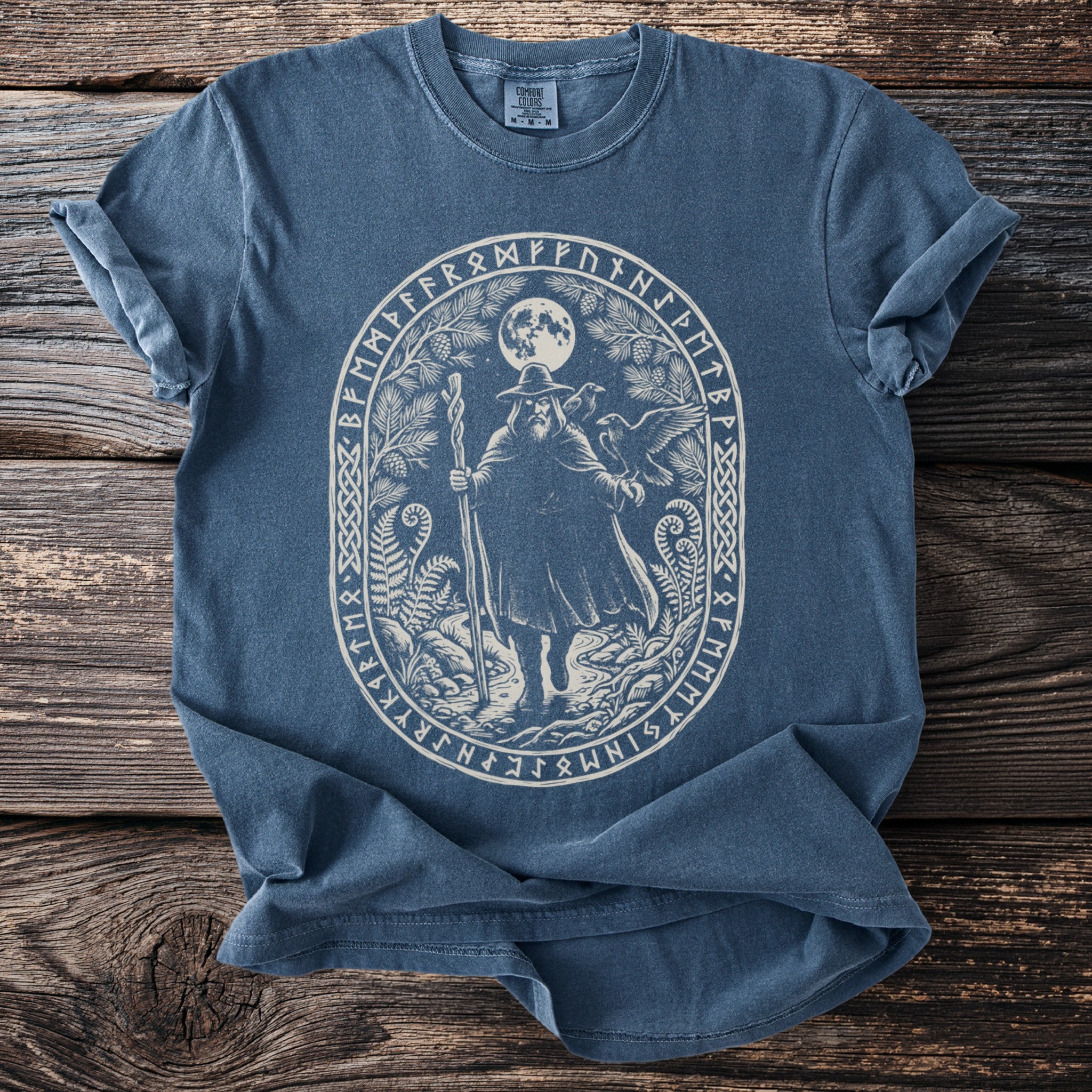 Blue t-shirt with an oval white graphic of a wizard and runes.