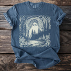 Blue t-shirt with a cream illustration of a ghost in a forest by a lake.