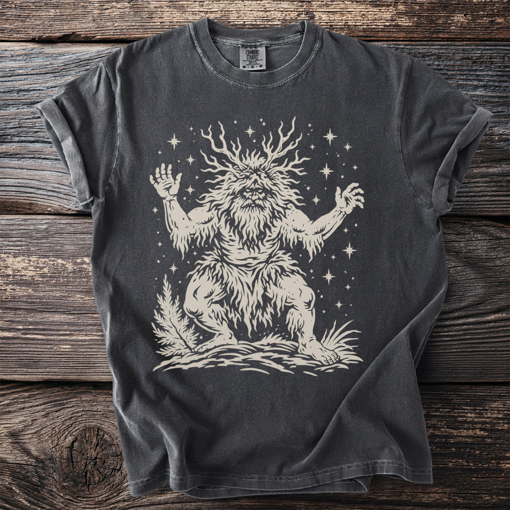 Charcoal t-shirt with cream print of a bushy-haired, antlered forest spirit surrounded by stars.