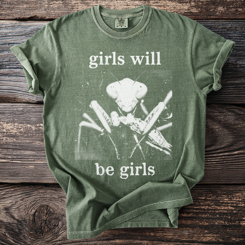 Green t-shirt with a white graphic of a praying mantis and text "girls will be girls".