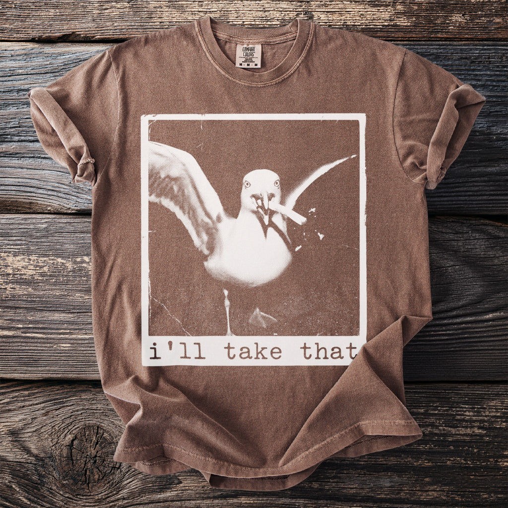 Brown t-shirt with a seagull graphic and text "i'll take that".