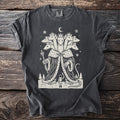 Pepper gray t-shirt with a cream folk-cut print: a seven-headed Mouse King in a royal robe and seven crowns faces a small toy soldier in the snow.
