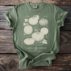 Green t-shirt with white illustration of pumpkins labeled "The Pumpkin Harvest".