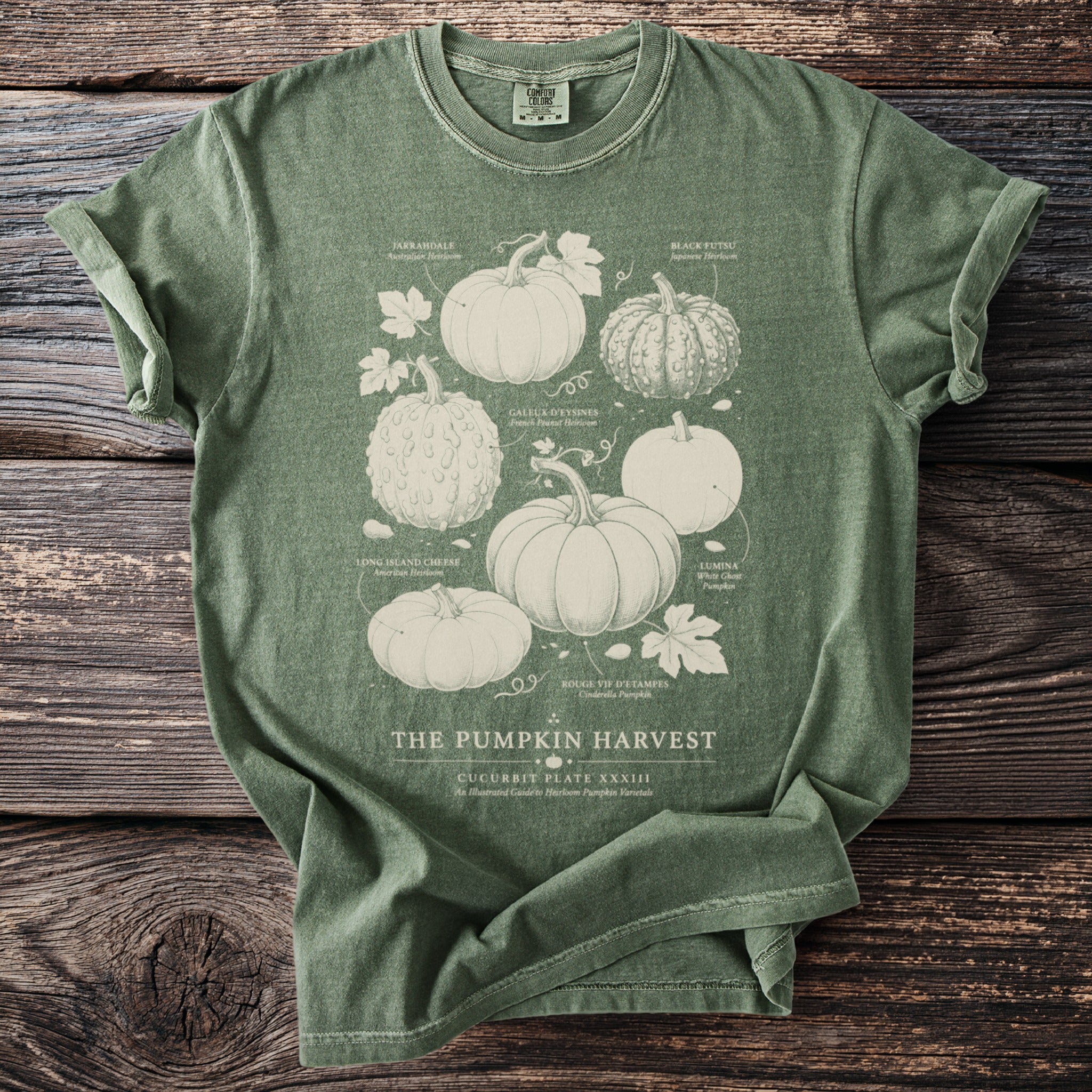 Green t-shirt with white illustration of pumpkins labeled "The Pumpkin Harvest".